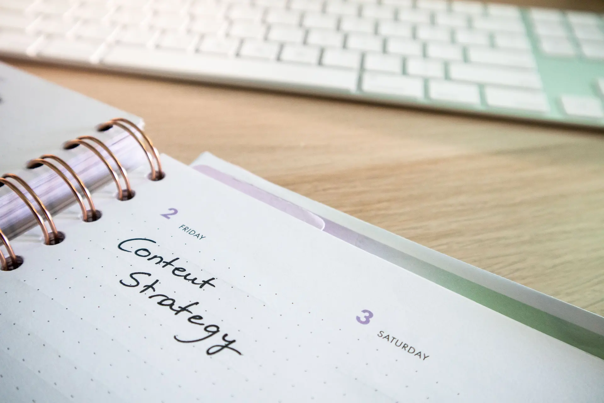 Planner de conteúdo aberto sobre a mesa com a anotação Content Strategy escrita à mão
