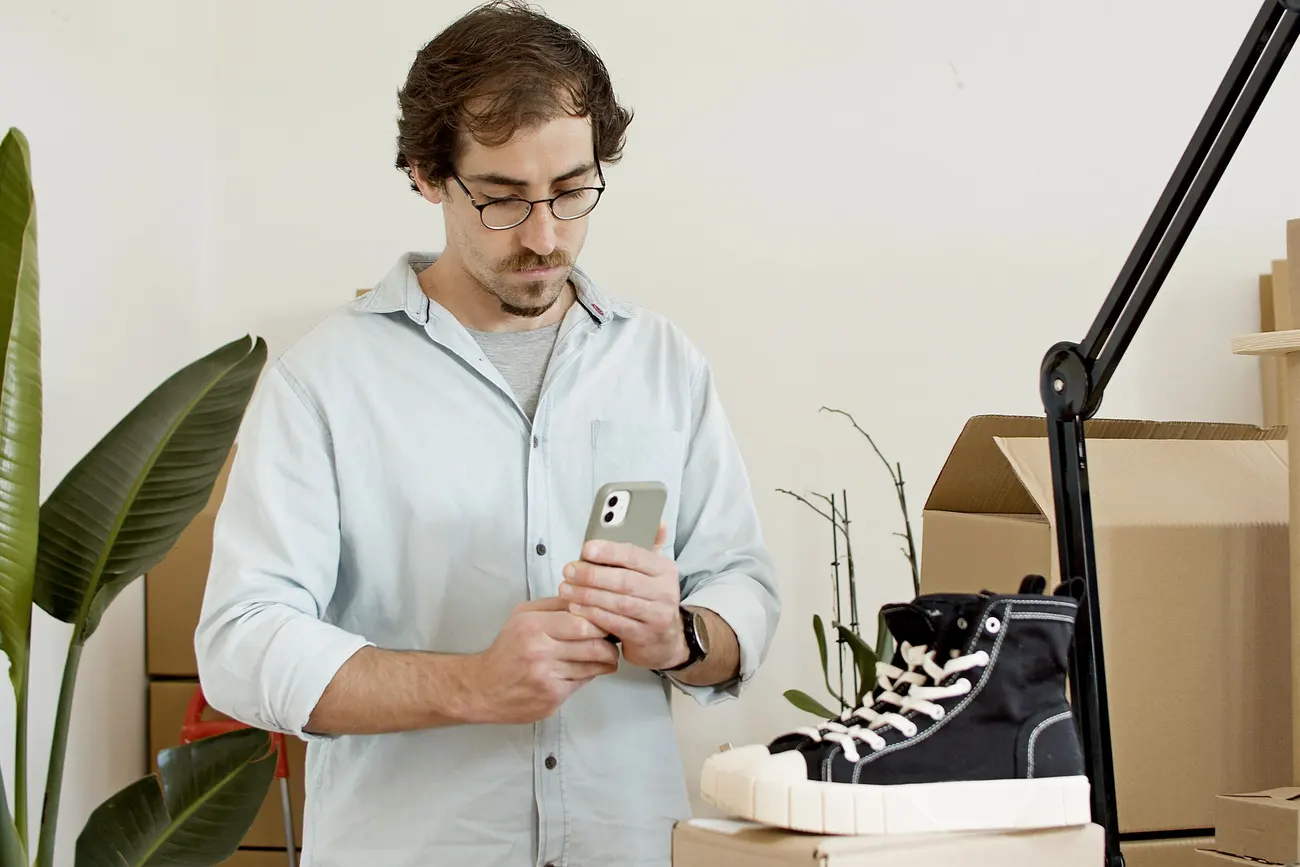 Pequeno empreendedor fotografa um produto com o celular para publicar online