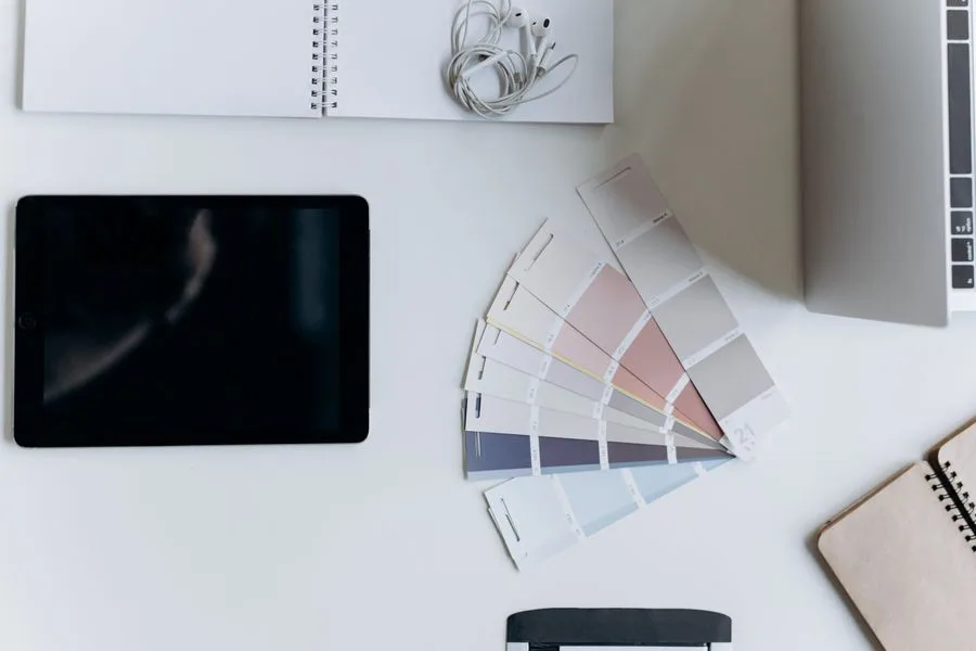 Mesa minimalista vista de cima com amostras de cores e gadgets